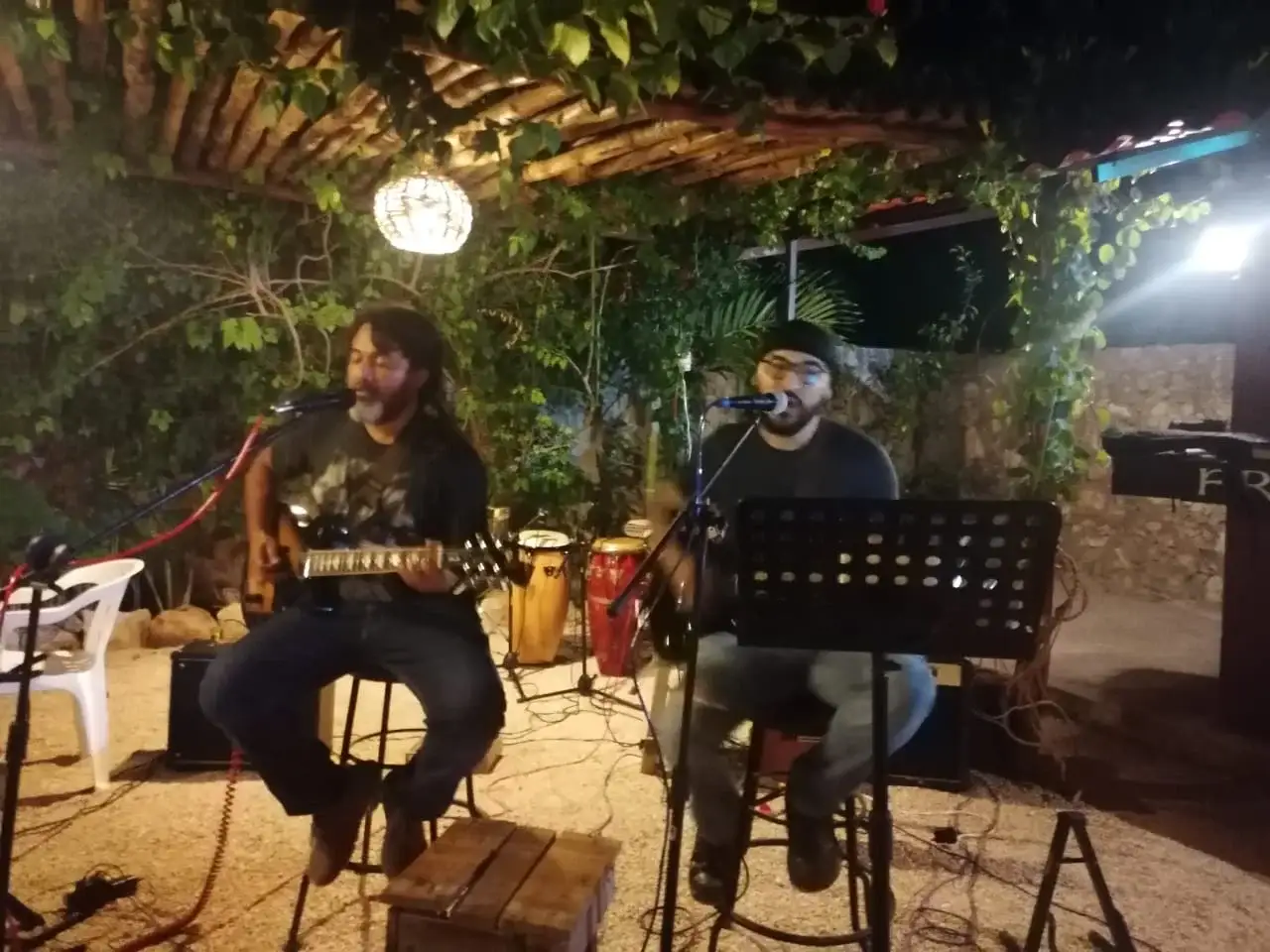 Two musicians performing acoustic live music in the courtyard