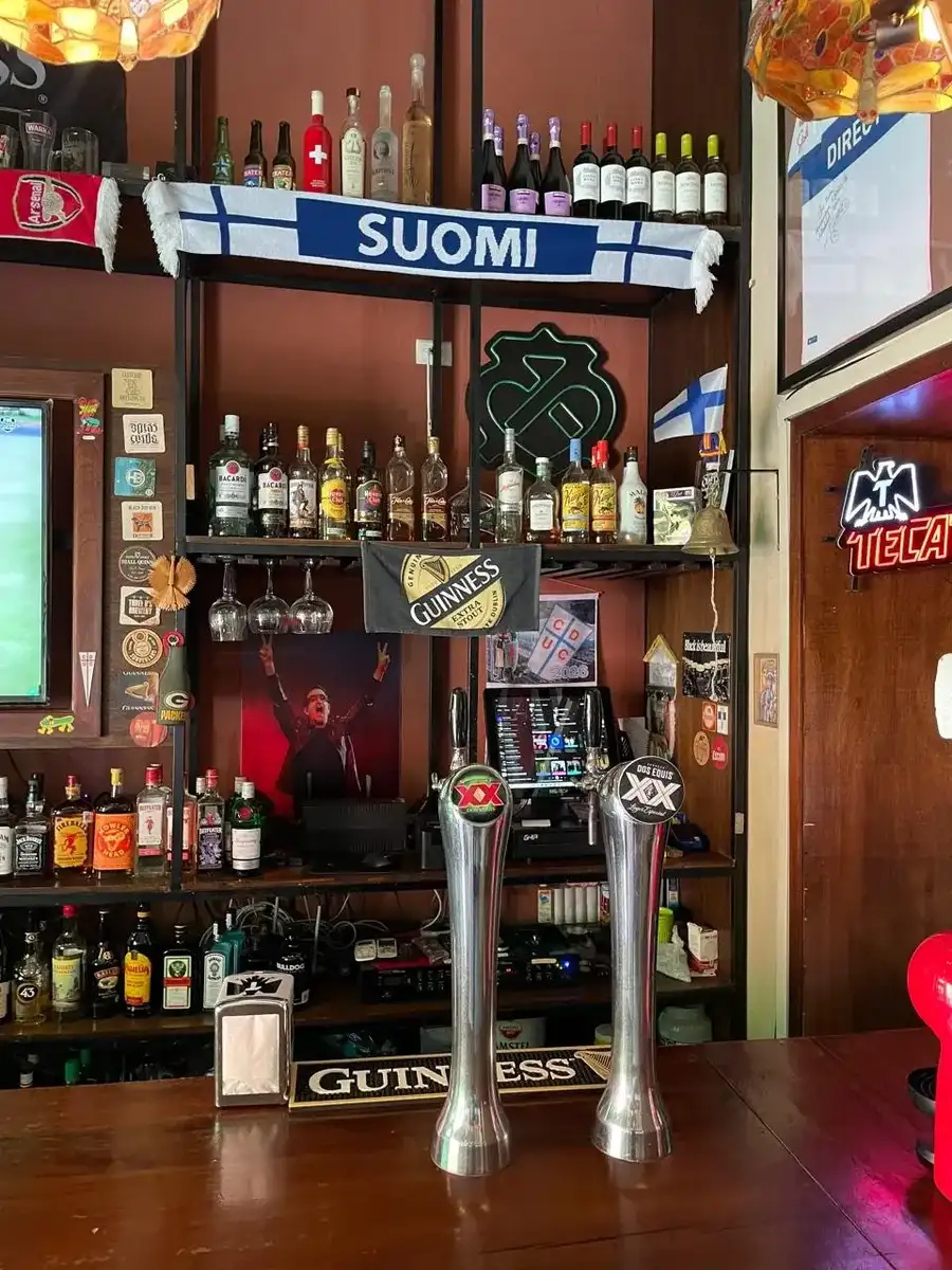Back bar at St Patrick's with sports screens, taps, and football memorabilia